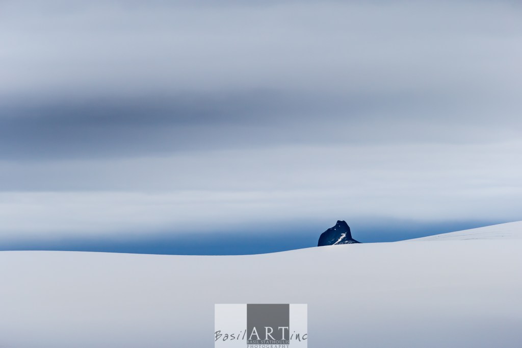 Black blue land on the horizon Swallows a single stony peak